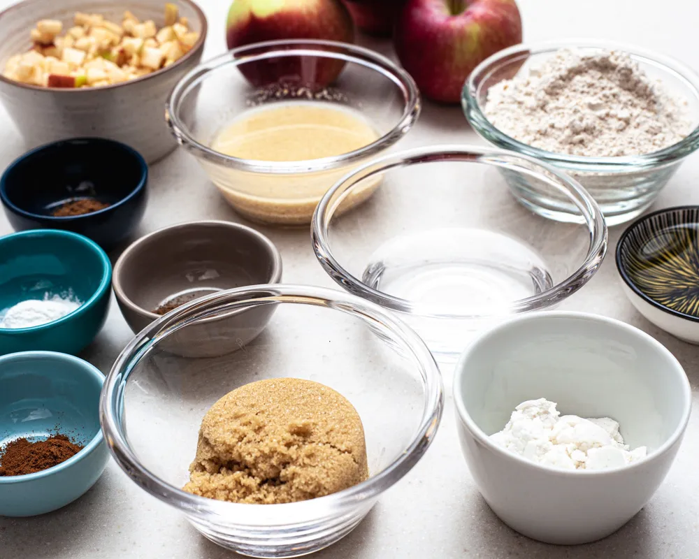 bowls with ingredients and apples on the background