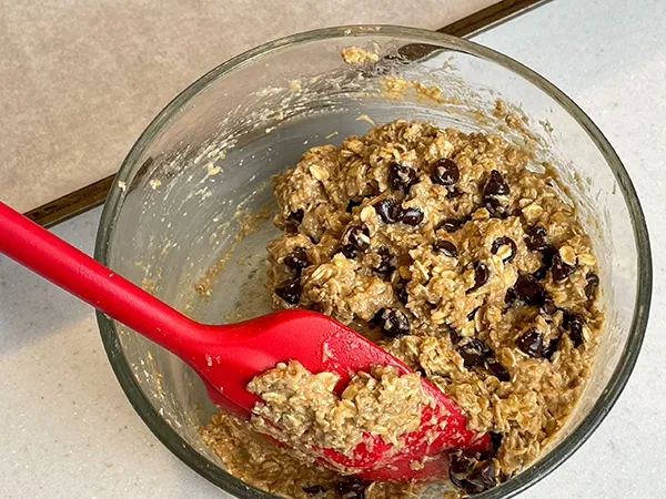 bowl with all the ingredients mixed together to make the best vegan chocolate chip cookies