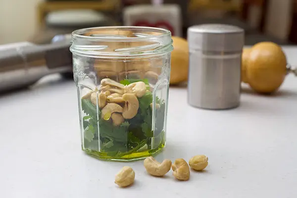 jar with cilantro leaves, cashews and olive oil