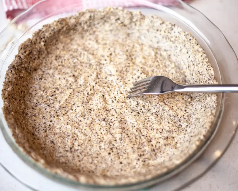 fork visible in a pan with pie crust made of chia seeds and oat flour.