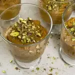 Apricot mousse on the serving glass topped with ground pistachios