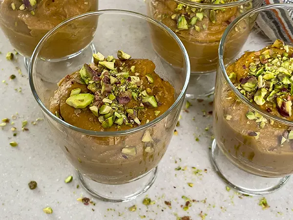 Apricot mousse on the serving glass topped with ground pistachios